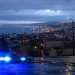 Vista urbana nocturna de la Región de Valparaíso con una luz de seguridad en primer plano