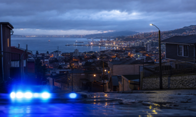 Vista urbana nocturna de la Región de Valparaíso con una luz de seguridad en primer plano