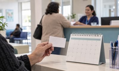 Persona sostiene una tarjeta de atención junto a un calendario en una recepción de salud
