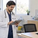 Médico revisa una ficha clínica en una consulta de atención primaria
