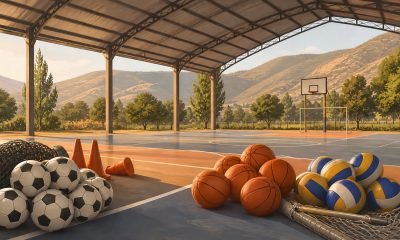 Balones de fútbol, básquetbol y voleibol en una cancha techada