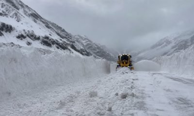 Máquina quitanieves despeja una ruta de alta montaña entre grandes bancos de nieve