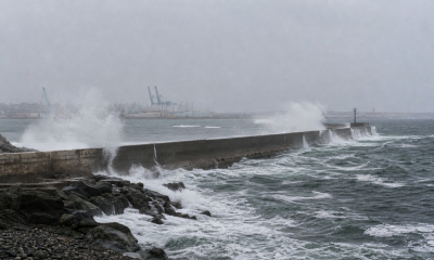 Molo portuario durante marejadas, imagen editorial referencial