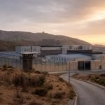 Ilustración editorial de un recinto penitenciario moderno en un paisaje de la Región de Valparaíso