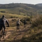 Ciclistas de montaña recorren un sendero rural entre los cerros de Pitama