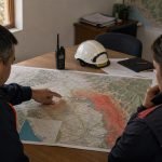 Dos profesionales revisan un mapa para planificar la reducción de riesgos de desastres