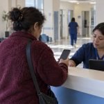Representación editorial de una paciente usando su teléfono durante una atención hospitalaria