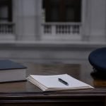 Libro jurídico y gorra policial genérica sobre un escritorio institucional