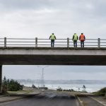 Puente urbano de hormigón junto a la costa, imagen editorial referencial