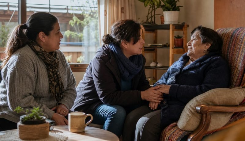 Trabajadora de cuidados acompaña en el hogar a una adulta mayor y su cuidadora