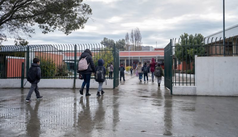 Estudiantes y apoderados ingresan a una escuela de Casablanca en una mañana de invierno después de la lluvia