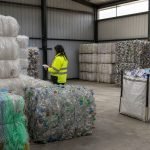 Trabajadores revisan fardos de materiales reciclables en una planta de segregación