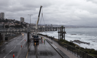 Imagen referencial del desmonte de una pasarela peatonal con grúa en una avenida costera tras un temporal