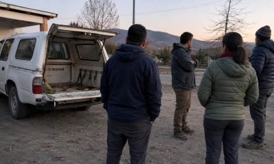 Camioneta con la parte trasera abierta junto a una comitiva en un sector rural