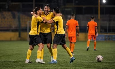 Futbolistas con uniforme amarillo celebran un triunfo en un estadio