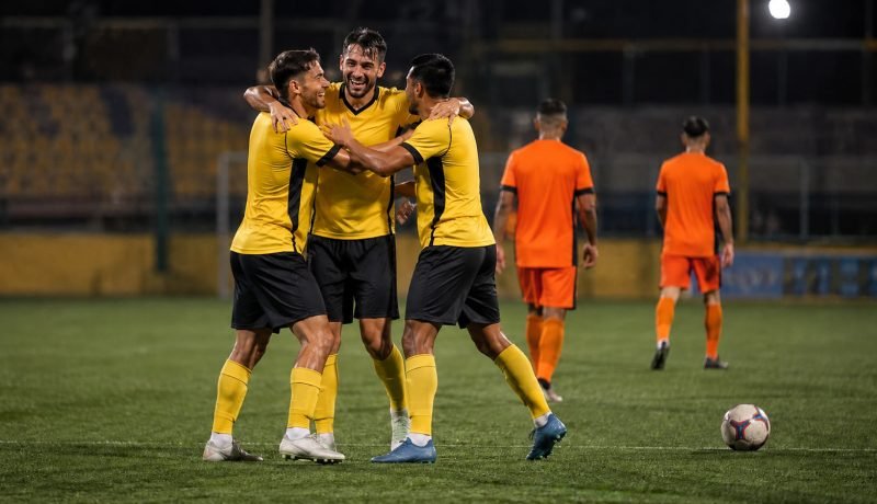 Futbolistas con uniforme amarillo celebran un triunfo en un estadio