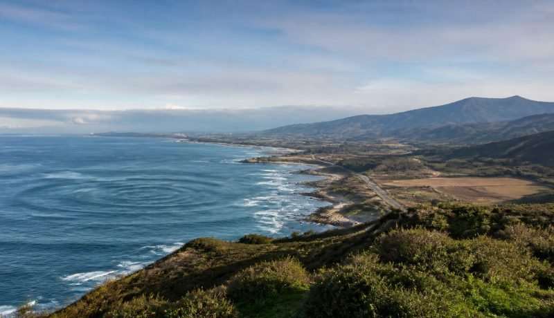 Costa central chilena con ondas circulares simbólicas sobre el mar
