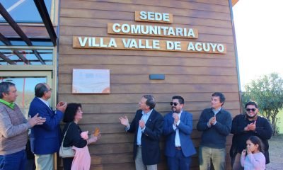 Personas frente a la sede comunitaria de Villa Valle de Acuyo, con el nombre del recinto visible en su fachada.
