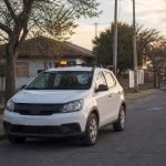 Vehículo genérico de seguridad comunitaria en una calle residencial al atardecer