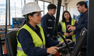 Mujer participa en una capacitación técnica de operación de maquinaria junto a un instructor y otros estudiantes