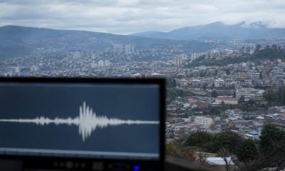 Monitor sísmico frente a una vista urbana de los cerros de Valparaíso