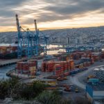 Vista de infraestructura portuaria con grúas y contenedores en la zona central de Chile