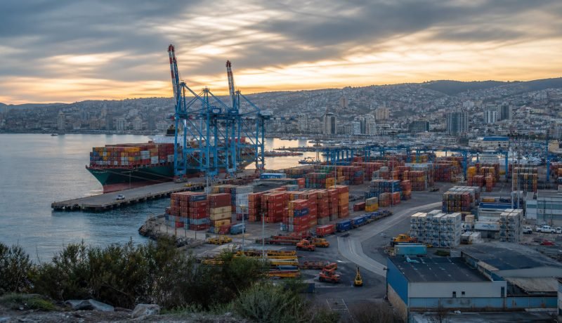 Vista de infraestructura portuaria con grúas y contenedores en la zona central de Chile