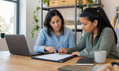 Dos mujeres revisan un contrato de trabajo en una pequeña empresa