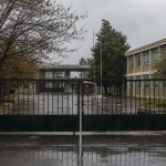 Entrada cerrada de un establecimiento educacional durante una jornada de lluvia invernal