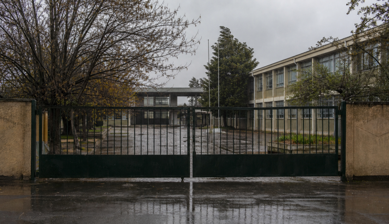 Entrada cerrada de un establecimiento educacional durante una jornada de lluvia invernal