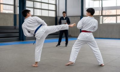 Jóvenes practican taekwondo durante una evaluación deportiva en gimnasio
