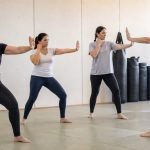 Mujeres adultas practican posturas básicas de defensa personal en un dojo