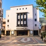 Fachada y acceso del Teatro Mauri SCD, con explanada peatonal y árboles.