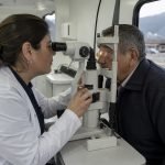 Profesional realiza un examen visual a un adulto mayor en una unidad oftalmológica móvil
