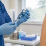 Trabajadora de salud prepara una vacuna antes de atender a una paciente