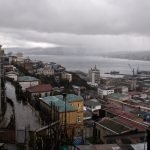 Vista de Valparaíso bajo cielo cubierto y lluvia, composición editorial referencial