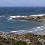 Mar con viento y oleaje frente a una bahía rocosa de la costa central de Chile