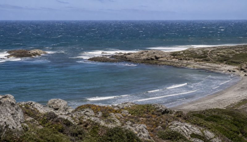Mar con viento y oleaje frente a una bahía rocosa de la costa central de Chile